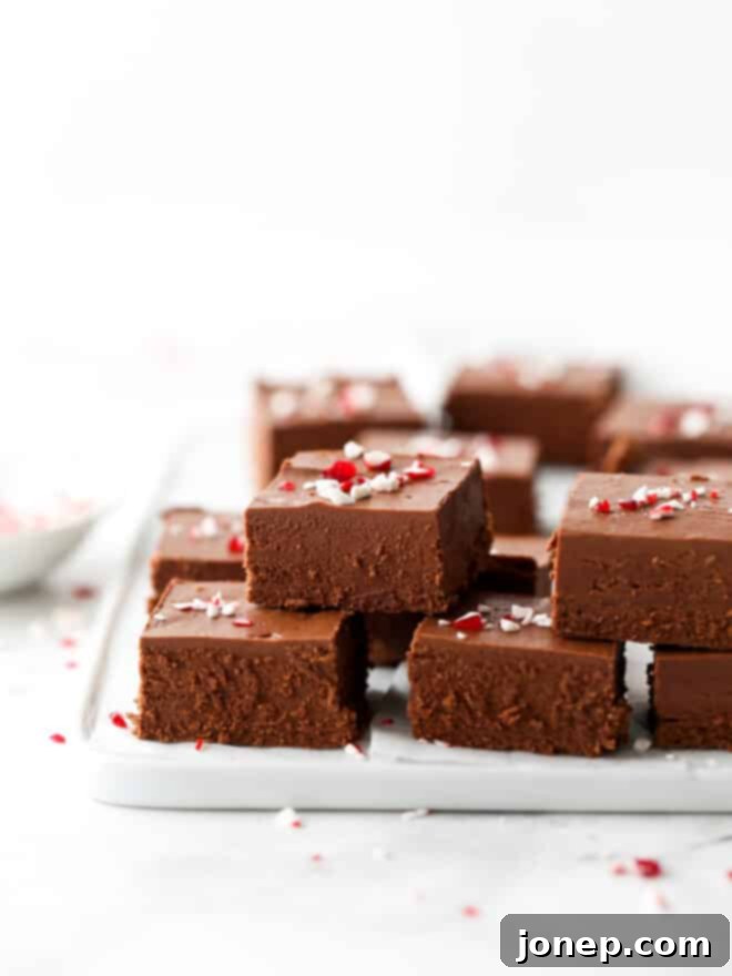 Lots of peppermint fudge stacked on a plate, showcasing its rich texture and festive appeal