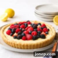 A slice of Lemon Berry Tart with a scoop of whipped cream