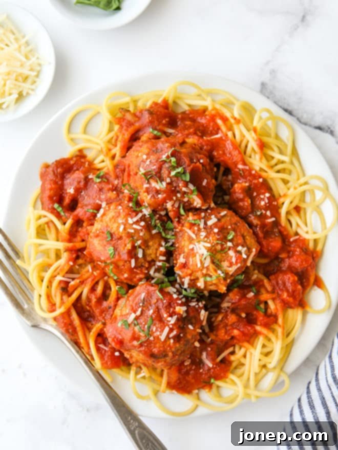 Garden Fresh Turkey Zucchini Meatballs 7 Close-up of a serving of turkey zucchini meatballs with marinara sauce and basil