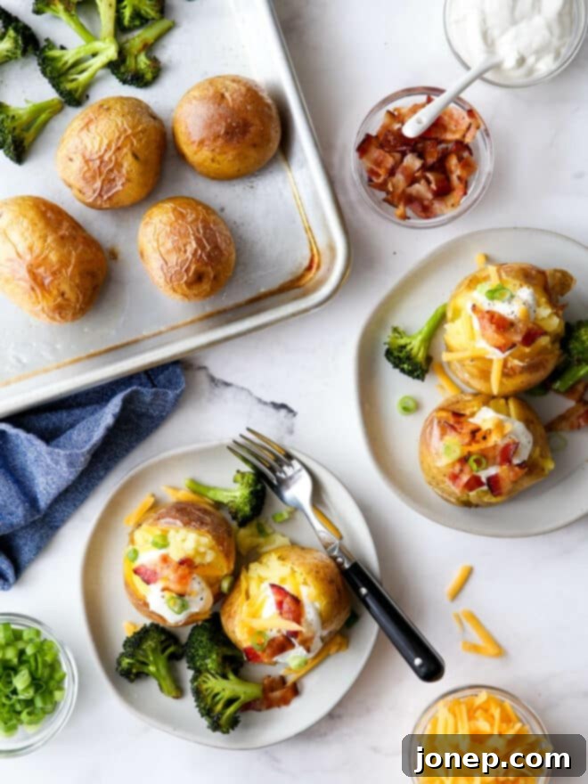 One-Pan Loaded Baked Potatoes 2 Plating baked potato servings with toppings and sheet pan in the corner, showcasing a delicious loaded baked potato sheet pan dinner.