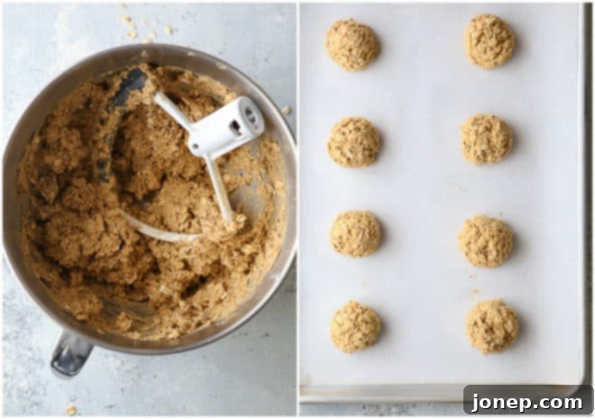 Perfectly Chewy Oatmeal Cookies 4 Scoops of raw chewy oatmeal cookie dough arranged neatly on a parchment-lined sheet pan, ready for baking