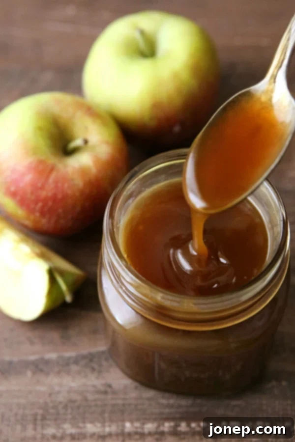 Rich, amber-colored homemade apple cider caramel sauce drizzled over a dessert.
