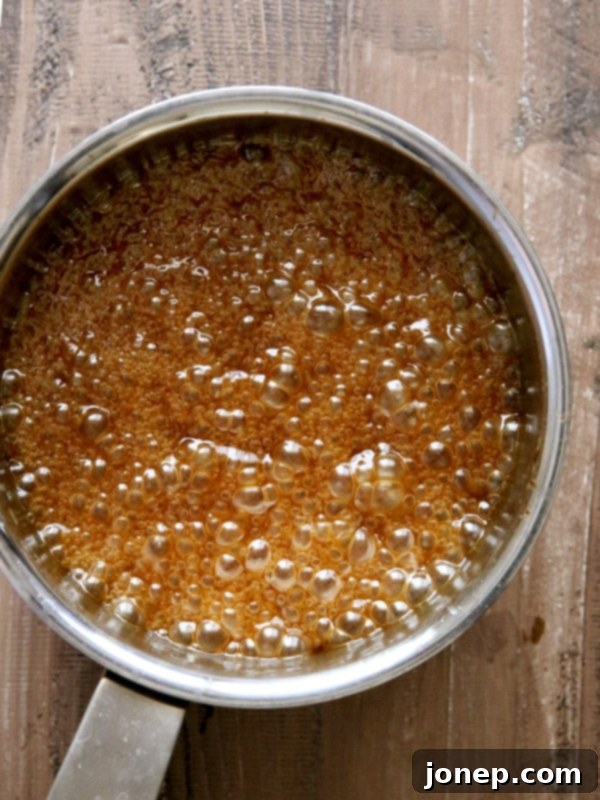 A jar filled with homemade apple cider caramel sauce, ready to be stored or served.