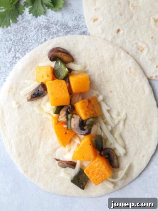 Assembling butternut squash, mushroom, and poblano enchiladas in a casserole dish