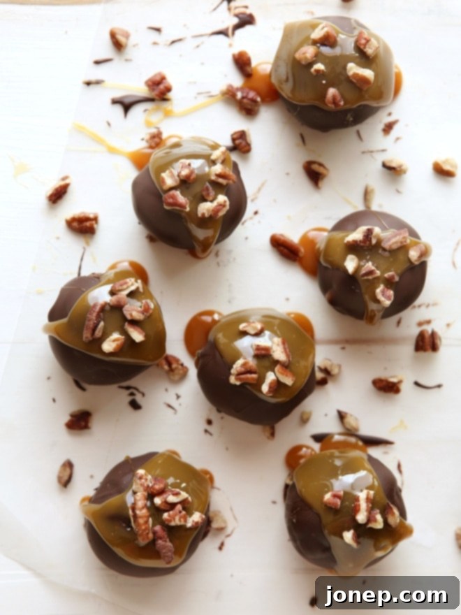 Hand picking up a Turtle Cookie Truffle, showing the rich texture and tempting ingredients | completelydelicious.com