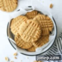 A plate of classic peanut butter cookies with a glass of milk.