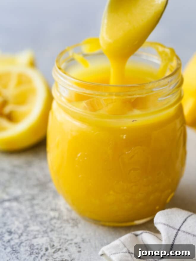 Delicious Homemade Lemon Curd 6 spooning lemon curd into jar