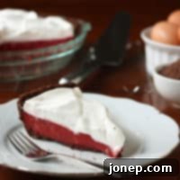 Crimson Dream Pie 2 Red Velvet Pudding Pie, side view with a slice removed, garnished with chocolate shavings.