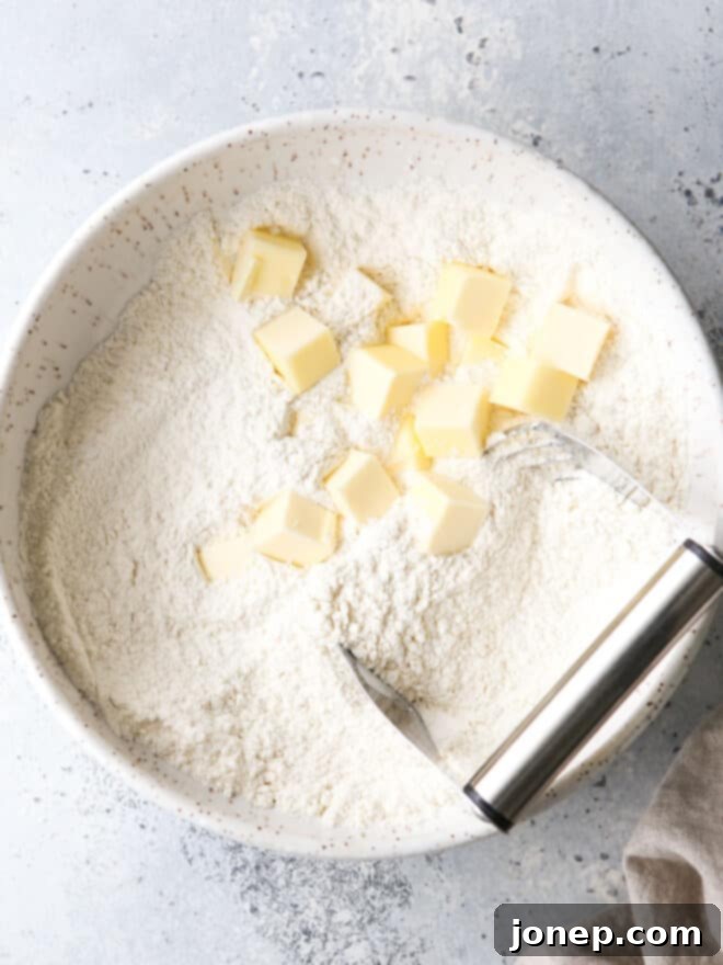 Mastering Butter Baking 2 cubed butter in a bowl with dry ingredients and pastry blender
