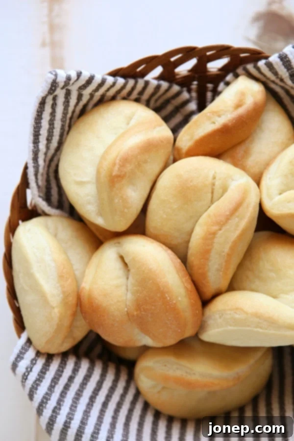 A basket full of golden Parker House Rolls, ready to serve.