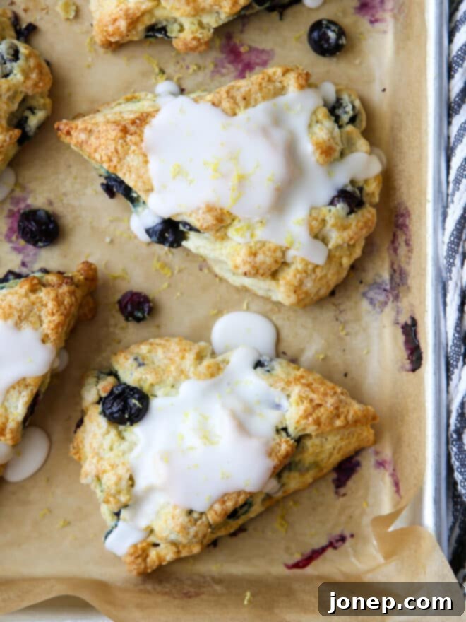 Zesty Lemon Blueberry Scones 3 Close-up of baked lemon blueberry scones cooling on a wire rack, showing their soft centers