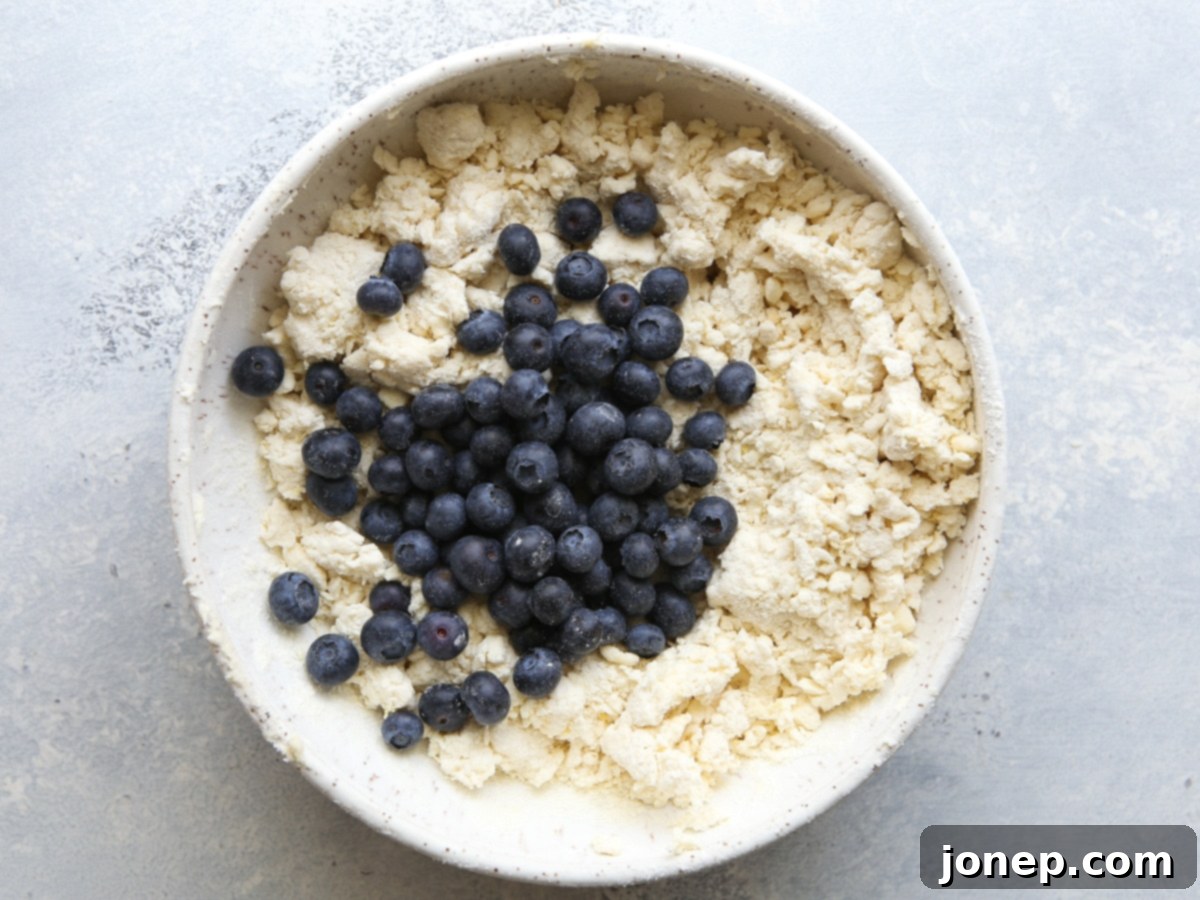 Cutting cold butter into dry ingredients using a pastry blender for scone dough