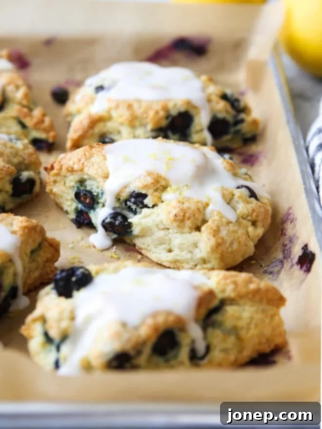 Zesty Lemon Blueberry Scones 7 Various angles of perfectly baked lemon blueberry scones, some with glaze, ready to be served