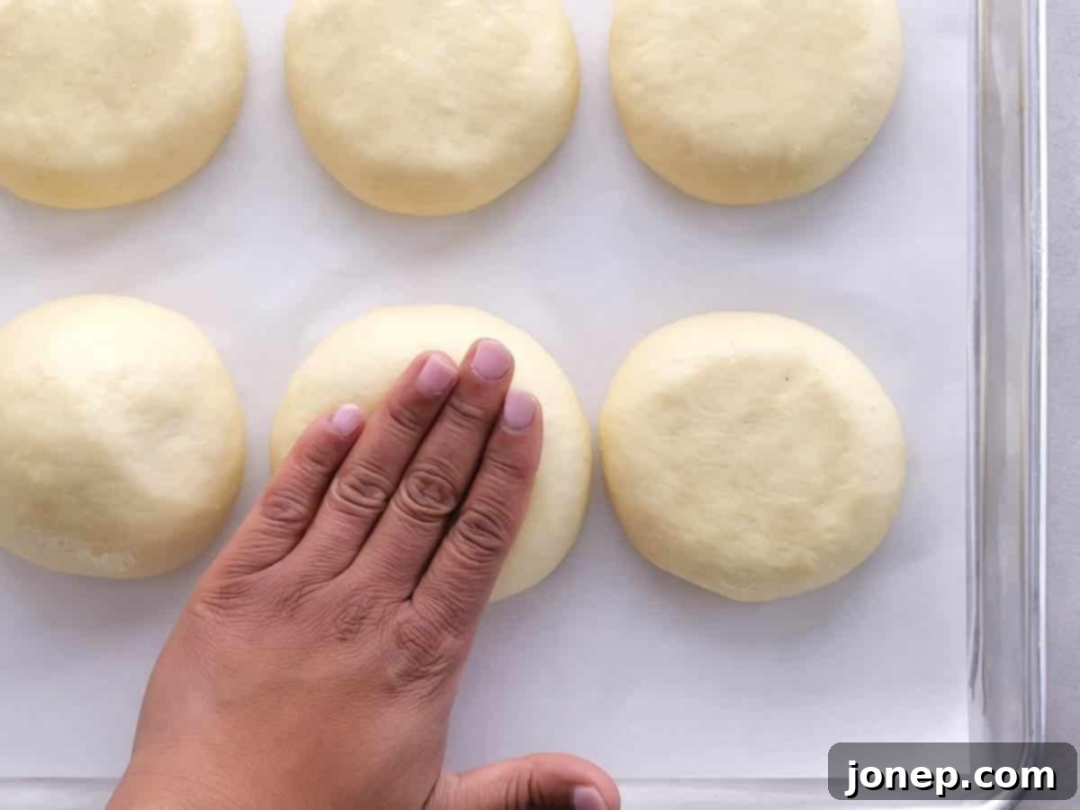 patting the tops so the burger buns expand horizontally