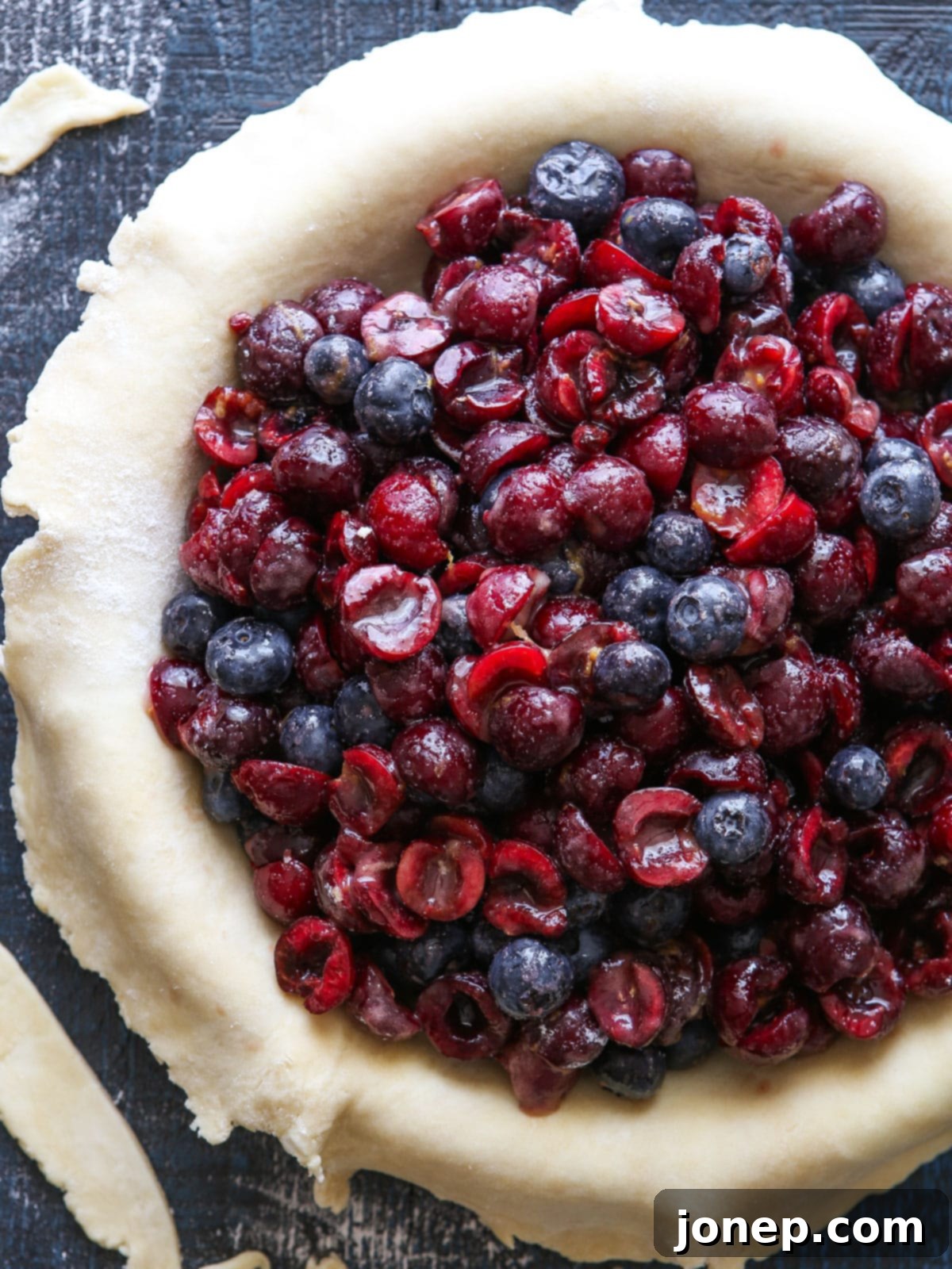 One disk of pie dough rolled out into a circle and placed inside a 9-inch pie dish, ready for filling.