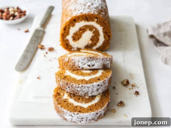 Classic Pumpkin Roll 10 sliced pumpkin roll cake with knife and candied pecans