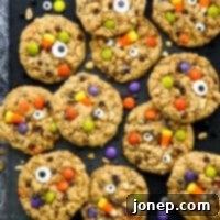 Ghoulish Halloween Cookie Delights 8 halloween monster cookies filled with candy on a black tray