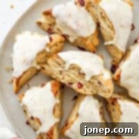 Eggnog Cranberry Scones
Festive Cranberry Eggnog Scones 9 Closeup of eggnog scones on a platter, showcasing their golden crust and cranberry filling.