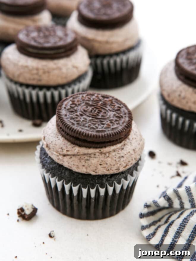 Oreo Bliss Bites 9 A beautiful, fully decorated Oreo cupcake with a platter of cupcakes in the background.