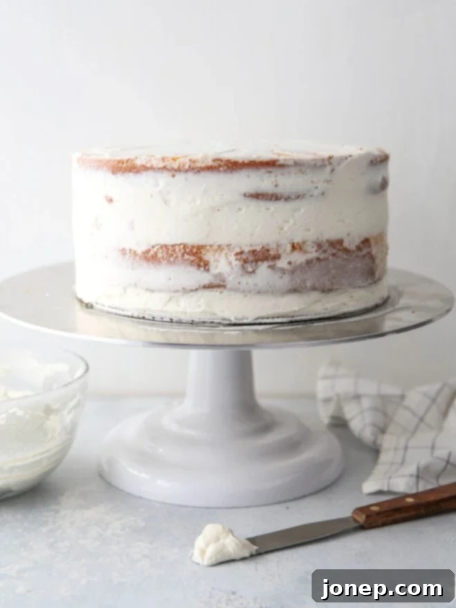 Frosted cake on turntable with spatula