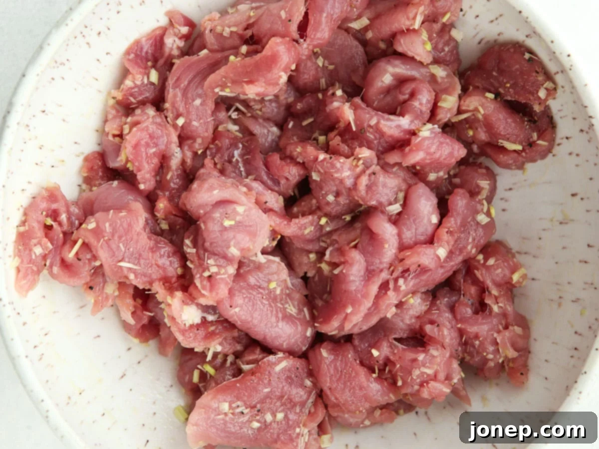Marinated pork tenderloin with lemongrass and ginger, ready to be stir-fried.