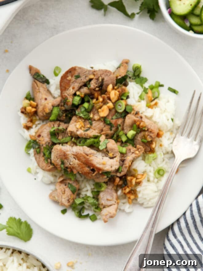 Close-up shot of marinated pork tenderloin with lemongrass and ginger, highlighting the fresh ingredients.