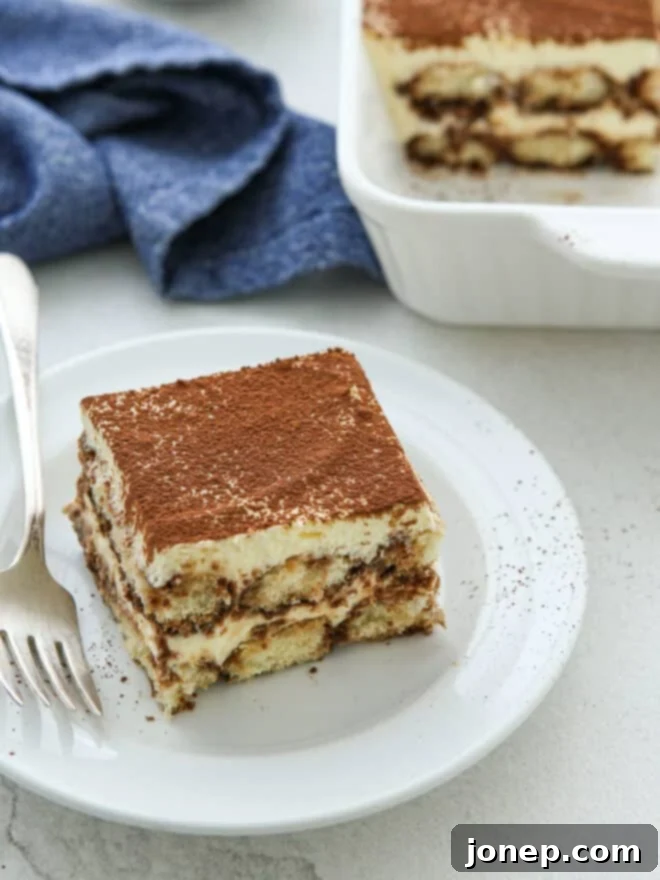 Timeless Italian Tiramisu 9 Another slice of tiramisu on a plate, ready to be enjoyed, emphasizing the deliciousness of this classic dessert.